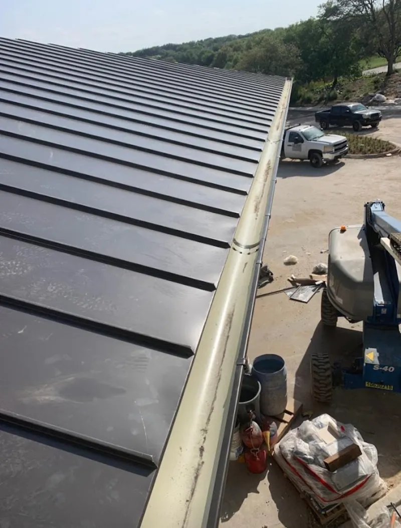 Standing seam panel and gutter detail on a metal roofing jobsite in Killingly